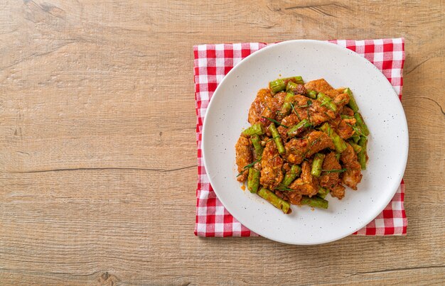 Mescolare il maiale fritto e la pasta di curry rosso con i fagioli