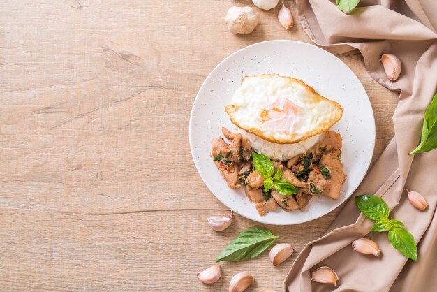 Carne di maiale saltata in padella con basilico su riso e uovo fritto