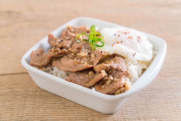 stir-fried pork with garlic on topped rice with egg