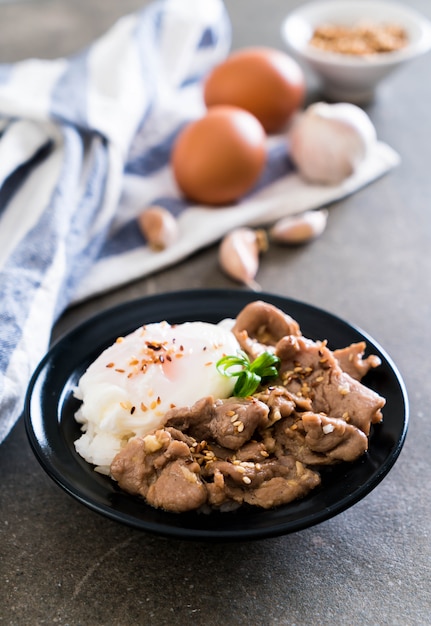 stir-fried pork with garlic on topped rice with egg