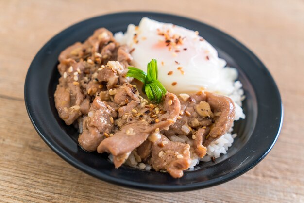 stir-fried pork with garlic on topped rice with egg