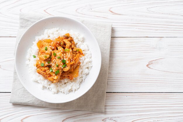 Foto maiale saltato in padella con kimchi su riso sormontato