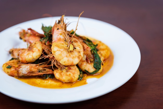 Stir fried red curry with shrimp Thai food on a wooden background