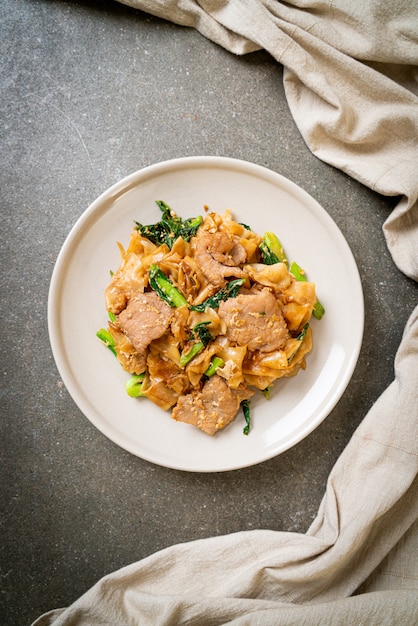 Stir-fried rice noodle with black soy sauce and pork and kale