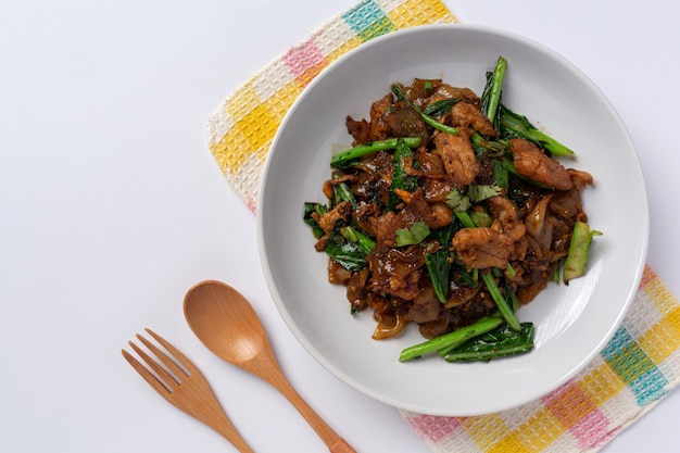 Stir fried rice noodles with soy sauce and pork  on white background