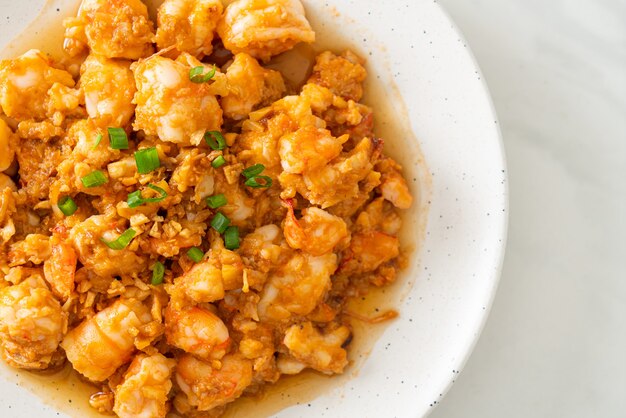 Stir-fried shrimps with garlic and shrimps paste on whie\
plate