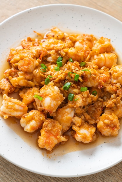 Stir-fried shrimps with garlic and shrimps paste on whie\
plate