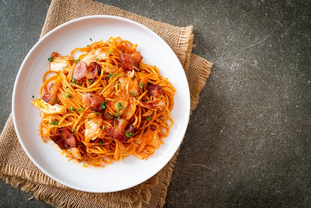 Stir-fried spaghetti with kimchi and bacon - fusion food\
style