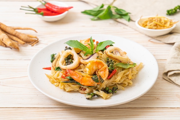 Mescolare le tagliatelle piccanti fritte con frutti di mare