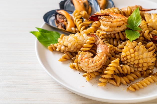 stir-fried spiral pasta with seafood and basil sauce - fusion food style