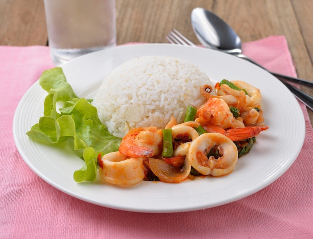 Stir fried squid with chilli and basil on white plate