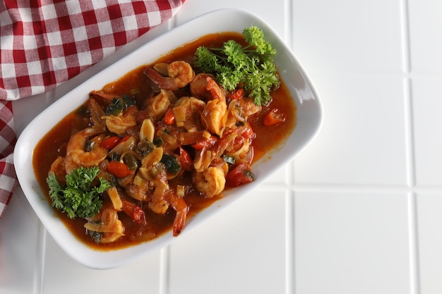 Stir-fried sweet and sour with shrimp served on white plate with white background