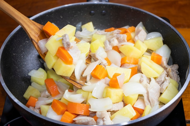 Mescoli le verdure fritte nella pentola, curry tailandese di massaman.