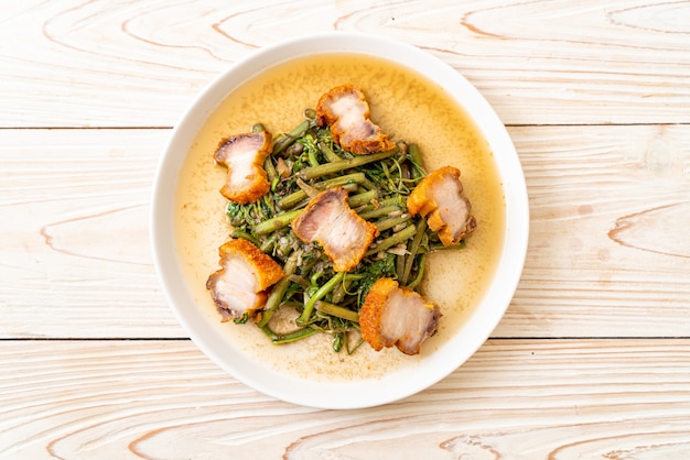 Stir-fried water mimosa with crispy pork belly on plate