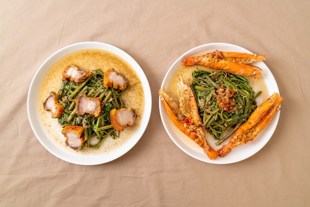 Stir-fried water mimosa with crispy pork belly and river prawns on plate