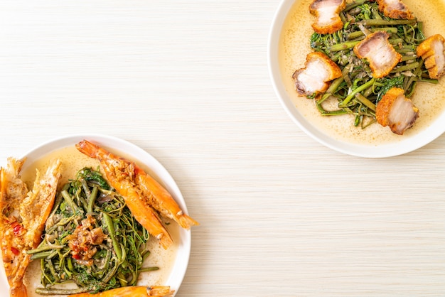 Stir-fried water mimosa with crispy pork belly and river prawns on plate