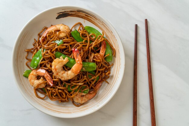 Spaghetti di yakisoba saltati in padella con piselli e gamberetti - stile di cibo asiatico