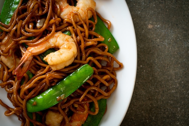 Stir-fried yakisoba noodles with green peas and shrimps - asian\
food style