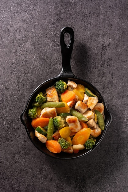 Stir fry chicken with vegetables on an iron pan