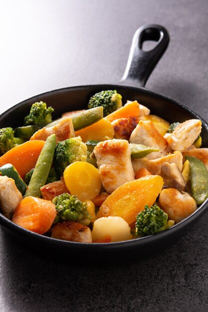 Stir fry chicken with vegetables on an iron pan