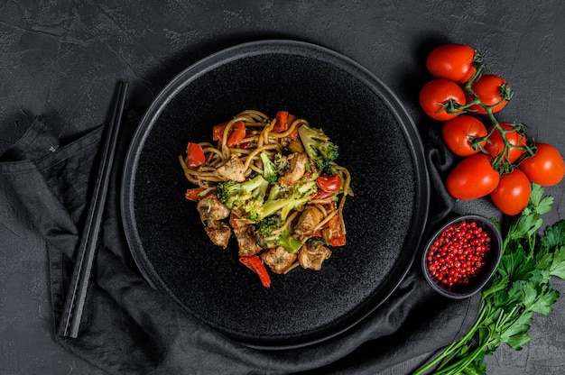 炒め麺、伝統的な中華なべ。箸、食材。