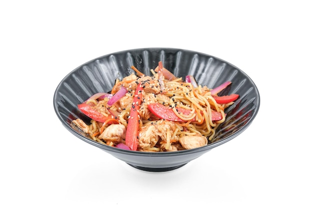Stir fry noodles with red bell pepper and red onion and chicken served in bowl isolated on white background