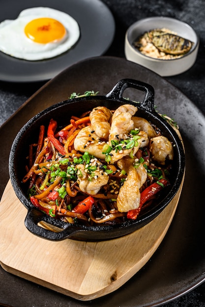 野菜、チキンと麺を炒めます。中華麺。黒の背景。上面図