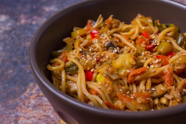 Stir fry noodles with vegetables on dark bowl