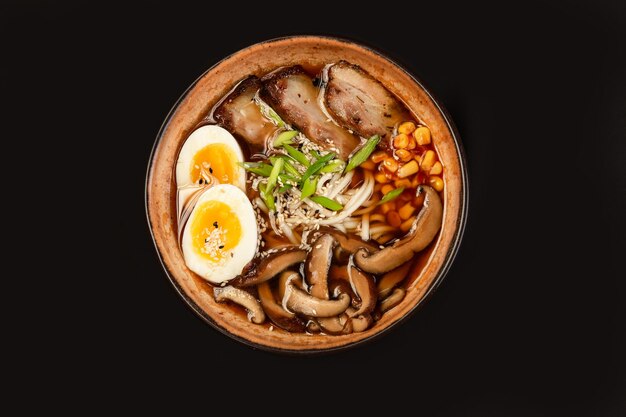 Stir fry noodles with vegetables and shrimps in black bowl Slate background Top view Copy space