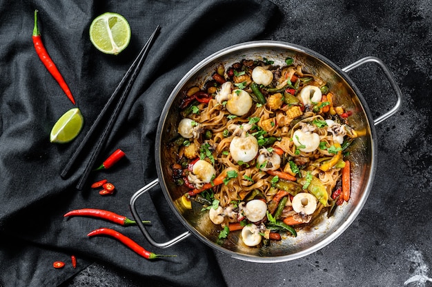 Saltare in padella le tagliatelle udon con frutti di mare e verdure