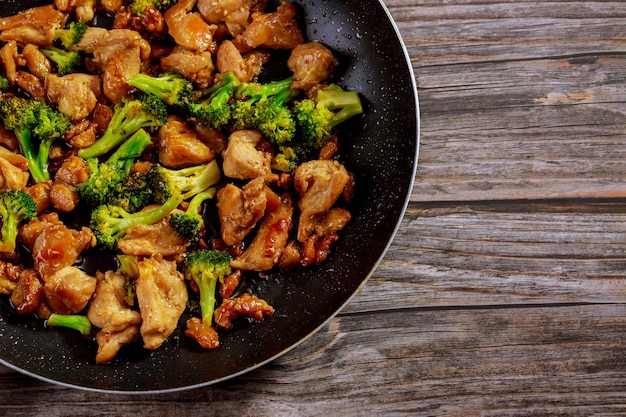 Stir fry with chicken and broccoli on wok. Chinese food. Close up.