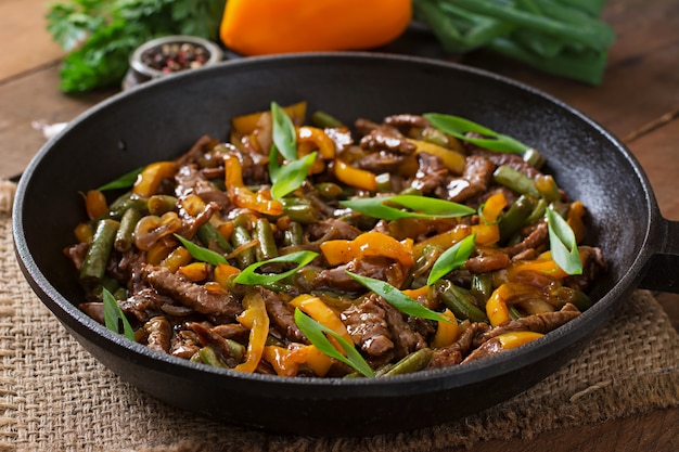 Stir frying beef with sweet peppers and green beans