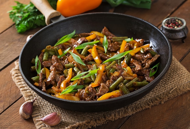 Stir frying beef with sweet peppers and green beans