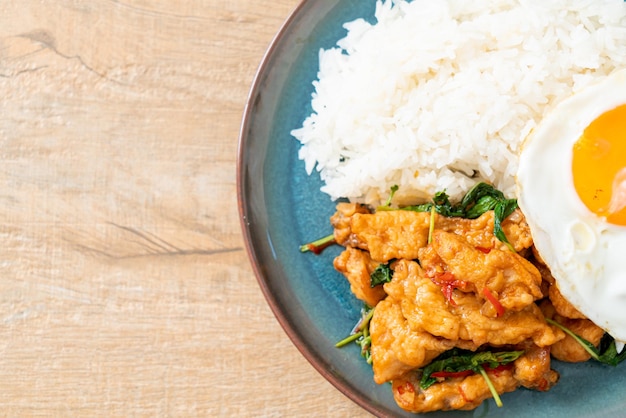 Stirfried fried fish with basil and fried egg topped on rice