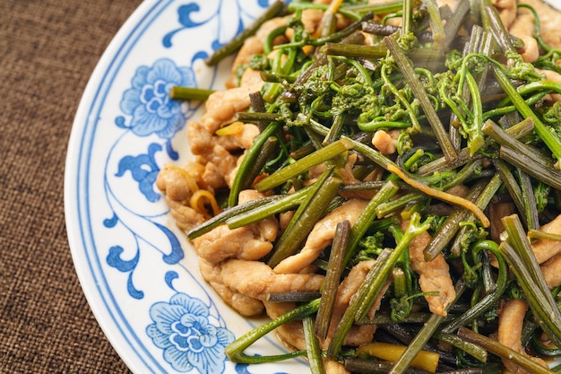 Stirfried meat with mountain bracken on a monochrome background