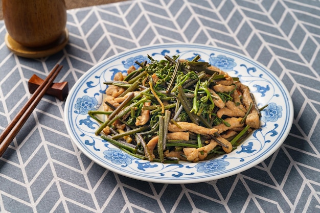 Stirfried meat with mountain bracken on a monochrome background