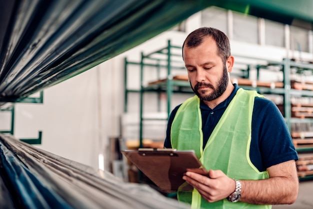 Stock clerk processing order for shipment in the warehouse factory