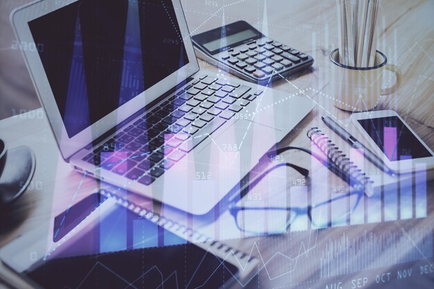 Stock market graph on background with desk and personal computer Multi exposure Concept of financial analysis