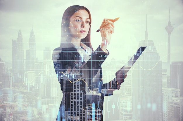 Stock market and investing analytics concept with young
businesswoman on skyscrapers background touching transparent
digital screen with graphs and numbers double exposure