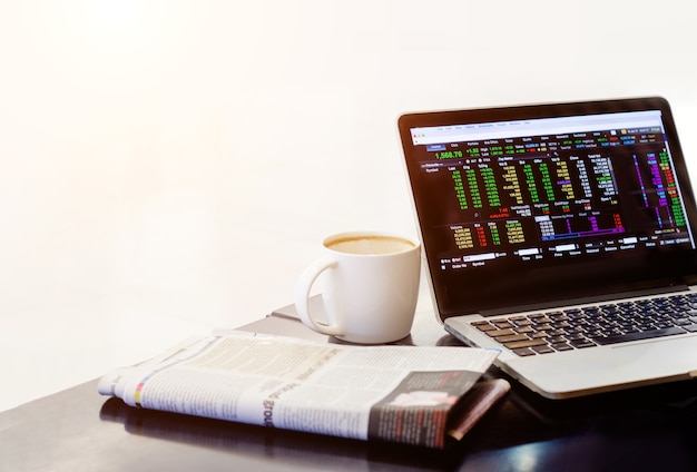 Photo stock market in notebook with newspaper and coffee cup