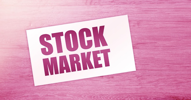 STOCK MARKET words on card on wooden table Business concept