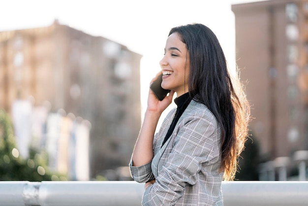 Фото Фондовый фото молодой деловой женщины, разговаривающей по телефону. она улыбается.