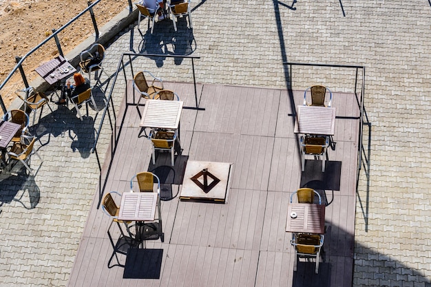 Stoelen en tafels in een gezellig straatcafé. Bovenaanzicht