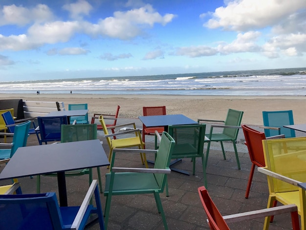 Foto stoelen en tafels op het strand tegen de lucht