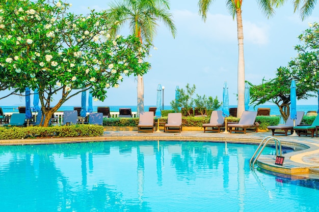 stoelzwembad en parasol rond zwembad met kokospalm - Vakantie- en vakantieconcept