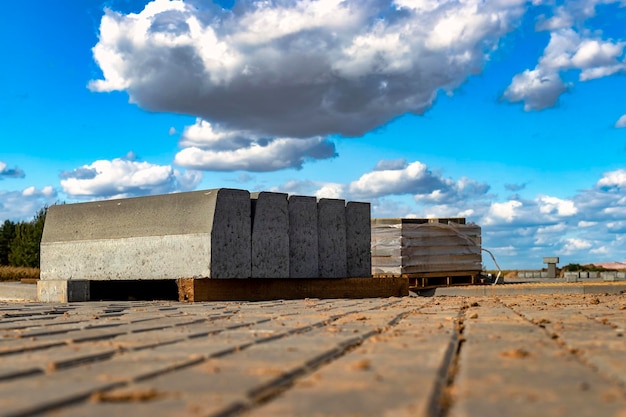 Stoeprand op de bouwplaats Pallet met een stapel betonnen trottoirband Wegreparaties Een paar stapels stoepranden die zijn voorbereid om te worden gelegd