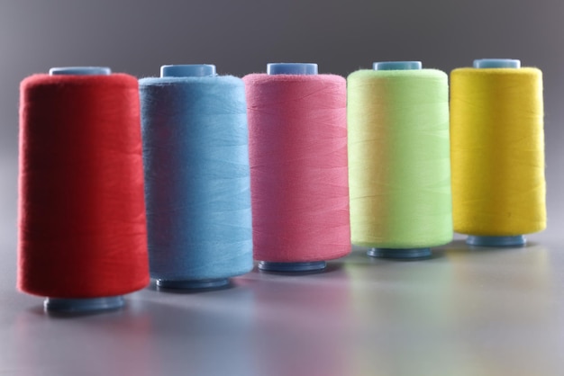 Stofdraden van verschillende kleuren op een grijze achtergrond