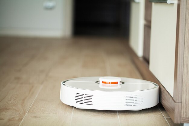 Stofzuigerrobot draait op houten vloer in een woonkamer