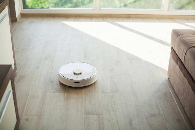 Stofzuigerrobot draait op houten vloer in een woonkamer