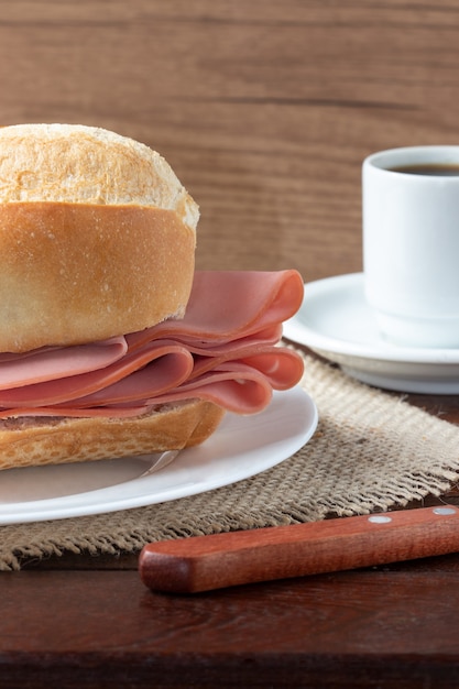 Stokbrood gevuld met mortadella en kopje koffie.